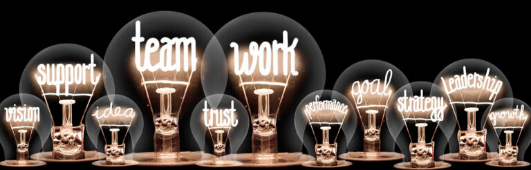 Mehrere Glühbirnen mit leuchtenden Begriffen wie Support, Team, Work, Trust, Goal, Strategy, Leadership und Growth.